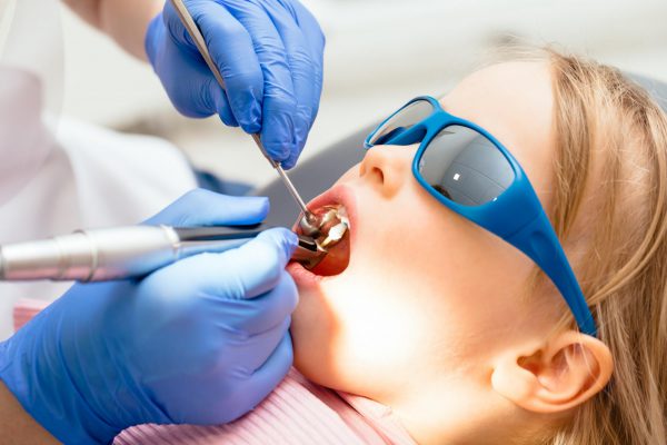 child with sunglasses on at the dentist office