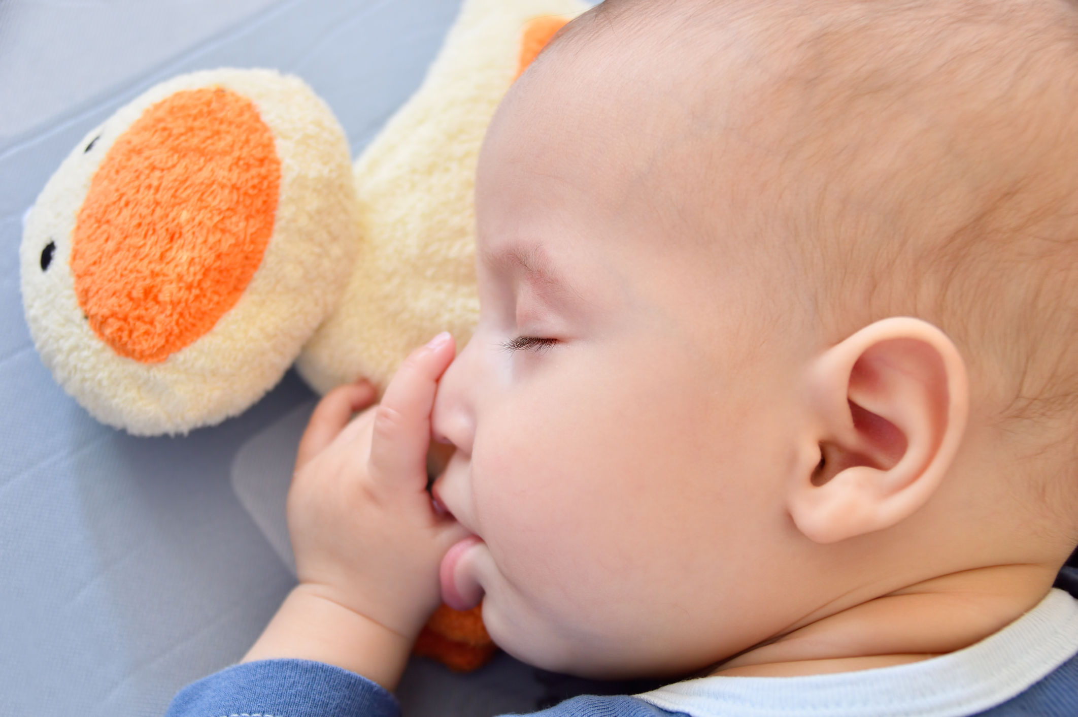 baby sleeping sucking its thumb